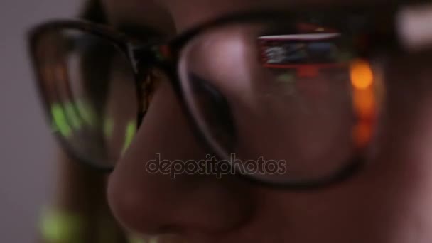 在黑暗中的女人眼镜浏览计算机代码反射。网络成瘾的概念. — 图库视频影像
