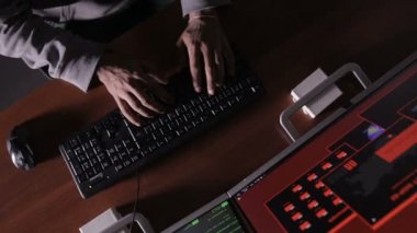 Karanlık odada bilgisayarlar kullanarak kod kırma hacker eller.