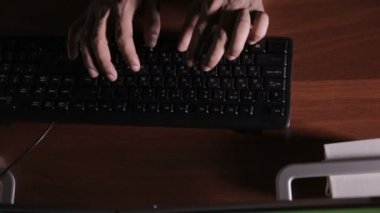 Üstten Görünüm. Adam karanlık bir odada bir klavye yazarak eller. Hacker, BT uzmanları, iş yerinde bilgisayar uzmanı. Tanınmayan.
