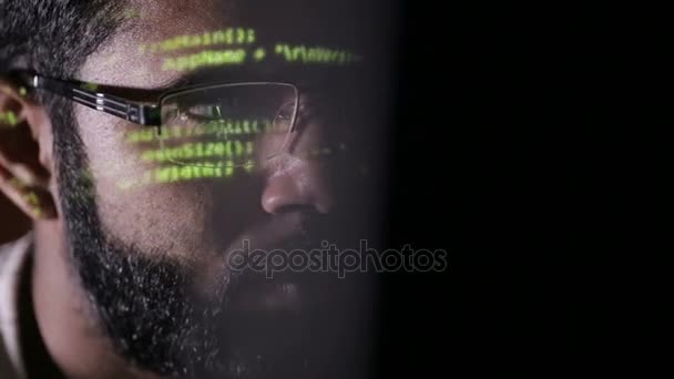 Un pirate informatique fonctionne. Code informatique réfléchi sur le visage . — Video