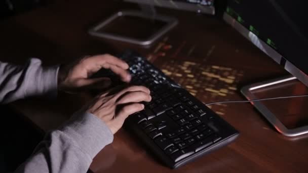 Το Top View. Ο άνθρωπος τα χέρια πληκτρολόγηση σε ένα πληκτρολόγιο σε ένα σκοτεινό δωμάτιο. Χάκερ, επαγγελματίας, ειδικός υπολογιστή στο χώρο εργασίας. Αγνώριστος. — Αρχείο Βίντεο