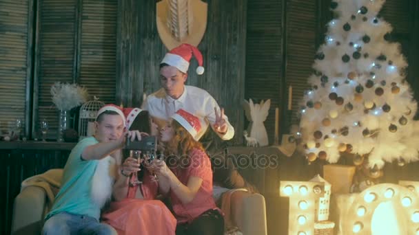 Hombres y mujeres jóvenes tomando fotografías de sí mismos en la fiesta de Navidad. Amigos alegres haciendo selfies. Movimiento lento . — Vídeo de stock