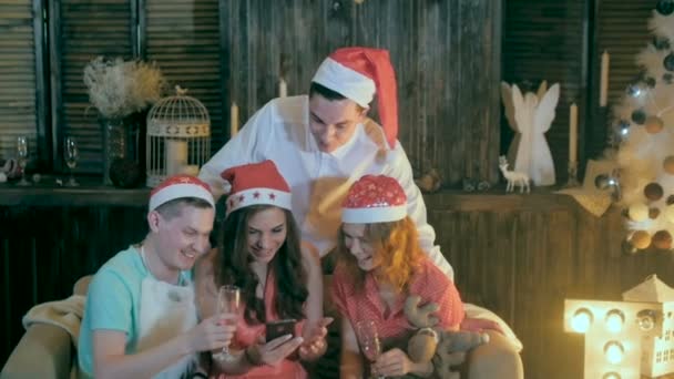 Adolescentes amigos despreocupados Celebre o Natal perto de Natal decorado assistindo vídeos smartphone . — Vídeo de Stock