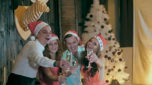 Alegre grupo de amigos cerca del árbol decorado de Navidad, beber alcohol de copas de vino riendo, divirtiéndose . — Vídeos de Stock