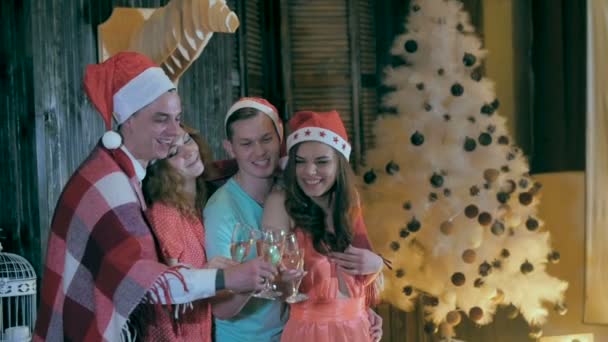Alegre grupo de amigos cerca del árbol decorado de Navidad, beber alcohol de copas de vino riendo, divirtiéndose . — Vídeo de stock