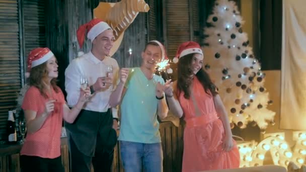 Grupo de amigos celebrando Navidad, Año Nuevo, divirtiéndose, bailando cerca del árbol de Navidad . — Vídeos de Stock