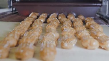 Konveyör hattı eklerleri hareket ile. Eller eklerleri, kek, pasta, tatlı bir üretim hattı koyarak.