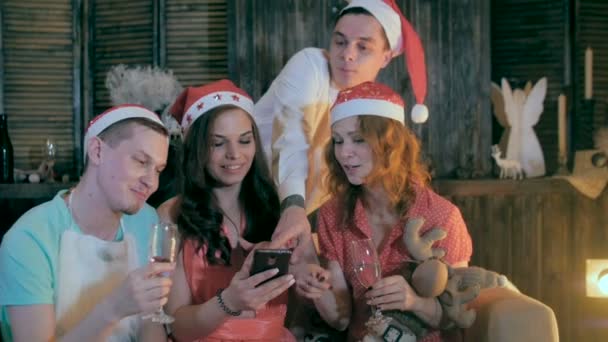 Ομάδα ανθρώπων, φίλους χρησιμοποιώντας το smartphone κοντά στο στολισμένο χριστουγεννιάτικο δέντρο. — Αρχείο Βίντεο