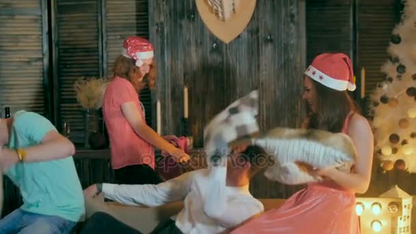 Fun Kissenschlacht. Freunde, die Spaß haben, gemeinsam Weihnachten feiern, mit Kissen spielen, lachen. — Stockvideo