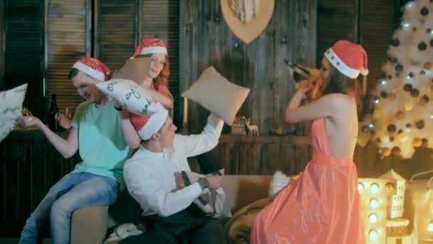 Fun Kissenschlacht. Freunde, die Spaß haben, gemeinsam Weihnachten feiern, mit Kissen spielen, lachen. — Stockvideo
