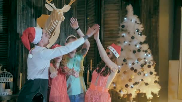 Slow motion. Glada kompisgäng på en julfest ha kul, ler in i kameran som firar julafton. — Stockvideo