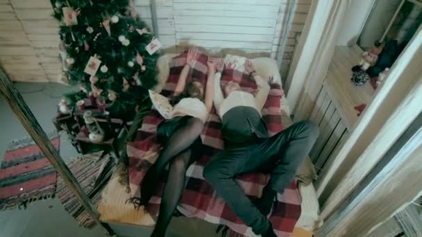 Pareja luchando con almohadas cerca del árbol de navidad decorado . — Vídeos de Stock