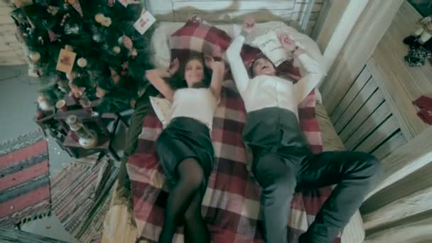 Pareja luchando con almohadas cerca del árbol de navidad decorado . — Vídeo de stock