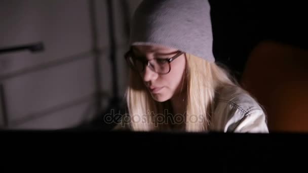 Серьезная молодая женщина за компьютером ночью в темной комнате . — стоковое видео