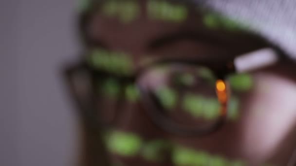 Ženu hacker pracující na počítači potmě v noci. Binární kód projekce na její tváři. — Stock video