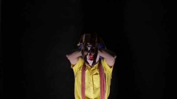 Злой клоун, выходящий из темноты и смотрящий в камеру . — стоковое видео
