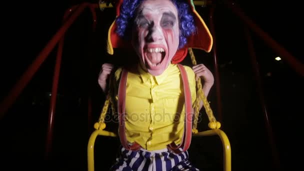 Моторошний клоун гойдається на нічній вулиці. Кошмарний малюнок . — стокове відео