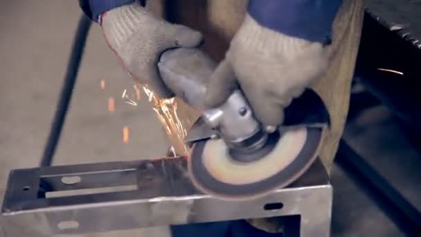 Worker using industrial grinder on metal parts in industrial plant, factory. — Stock Video