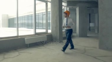 Bina inceleme yatırımcı. Baret inşaat ilerleme inceleyerek inşaat alanı içinde işadamı.