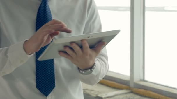 Tablet στα χέρια επιχειρηματία, μέσα σε ένα εργοτάξιο. Ρυθμιστικό σουτ. — Αρχείο Βίντεο