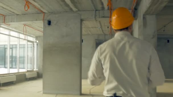 Investitore che ispeziona l'edificio. Uomo d'affari in cappello duro all'interno del cantiere esaminando i progressi della costruzione . — Video Stock