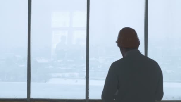 Arquitecto, ingeniero, diseñador cerca de ventana panorámica trabajando con plano y tableta . — Vídeos de Stock