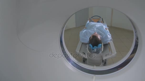 Patiënt in een noodsituatie ziekenhuis Mri-scanner. Man legt in magnetische resonantie beeldapparaat, waardoor tomografische scannen. — Stockvideo
