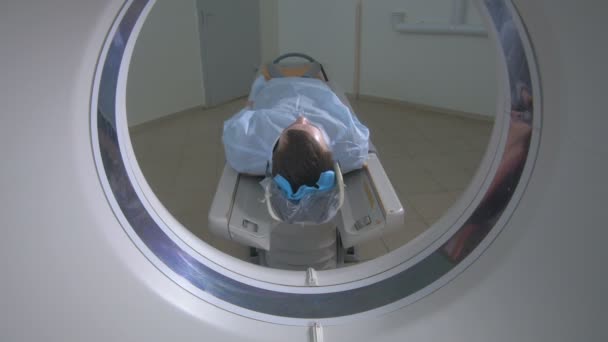 Paciente em um scanner de RM de hospital de emergência. O homem coloca no dispositivo da imagem da ressonância magnética, fazendo a varredura tomográfica . — Vídeo de Stock