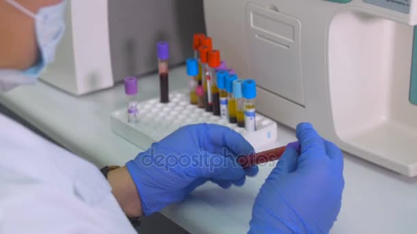 Τεχνικός εργαστηρίου λειτουργίας σωλήνες δοκιμής, τα δείγματα αίματος στο εργαστήριο με τη χρήση σύγχρονου ιατρικού εξοπλισμού. — Αρχείο Βίντεο
