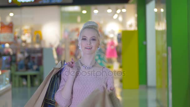 Stylish beauty girl with shopping bags posing in trade center after shopping. — Stock Video