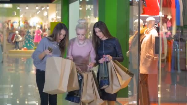 Eccitato, shopaholics felice, ragazze, amici si mostra borse della spesa in un centro commerciale . — Video Stock