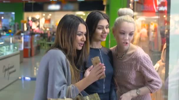 Happy young girls excitedly looking at shop window, showcase. Consumerism and people concept. — Stock Video