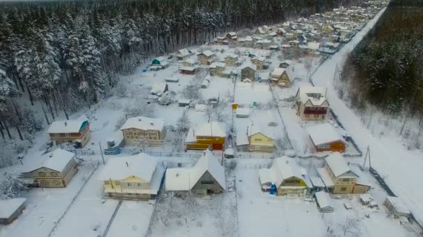 Μικρό χωριό μέσα στο δάσος του χειμώνα. Εναέρια, κορυφαία προβολή. — Αρχείο Βίντεο
