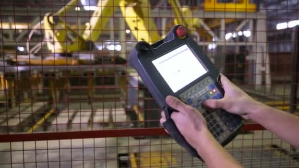 Homem operando equipamentos robóticos com controle remoto na fábrica industrial, planta . — Vídeo de Stock