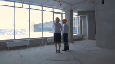 İş adamı ve iş kadın takım, yeni bir bitmemiş iş yeri zor şapka iletişim kurmak, tartışmak plan, şantiye.