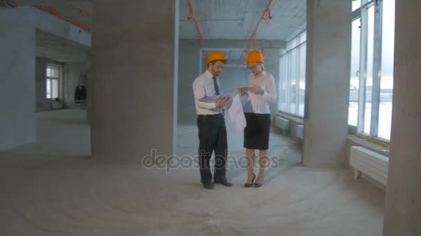 Homme d'affaires et femme d'affaires en costume, casque dur communiquer, discuter du plan, chantier de construction . — Video