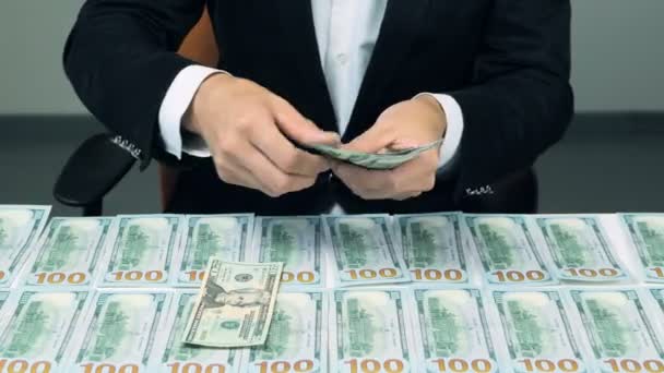 Homme comptant beaucoup de dollars américains. Beaucoup de billets de 100 dollars sur la table . — Video