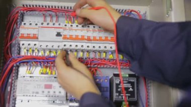 Devre kesici, test, multimetre ile bir sigorta kutusu çalışma elektrikçi.