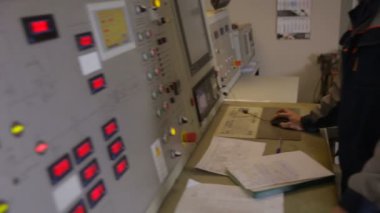 Kontrol panelinde kontrol Oda BM Santrali yakınındaki çalışan mühendis. Ölçümlerin yazılı sonuçları.