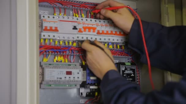 Manos electricistas comprobando disyuntores en caja de fusibles eléctrica . — Vídeos de Stock