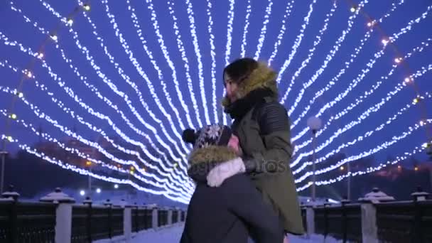 Man snurrar runt sin flickvän i hans händer. Vinter jul kväll. — Stockvideo