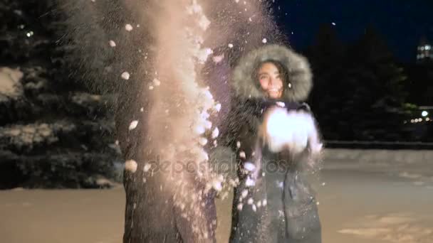 Una alegre pareja vomita nieve. Día de San Valentín. Movimiento lento . — Vídeos de Stock