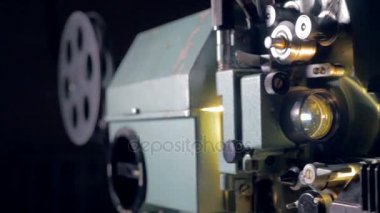 Film projektör. Eski film projektör karanlıkta çalışma. Ses. Dolly vurdu. Yakın çekim.