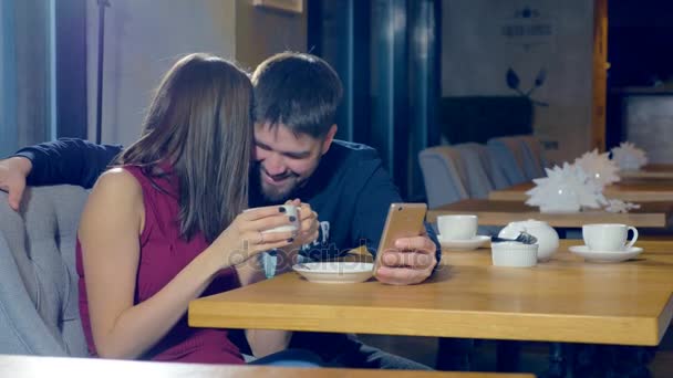 Aantrekkelijke jonge koppel met smartphone, met behulp van nieuwe app, samen lachen. — Stockvideo