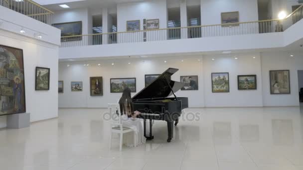 Muzikale pianist speelt klassieke grand piano in een centrum van concertzaal. Steadycam schot. — Stockvideo