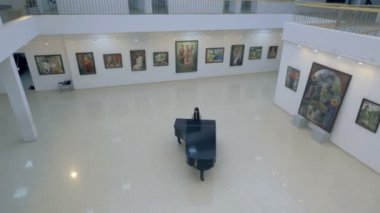 Müzikal piyanist klasik grand piyano konser salonu merkezinde. Steadycam atış.