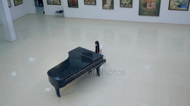 音楽のピアニストで、コンサート ホールの中心の古典的なグランド ピアノします。ステディカム ショット. — ストック動画