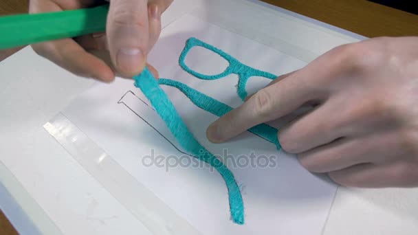 Чоловік складає окуляри з 3D ручкою. Інноваційні технології виробництва . — стокове відео