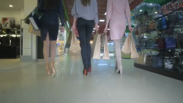 Delgadas piernas de mujer joven, caminando en la tienda. Vista trasera, cámara lenta, toma de stedicam . — Vídeos de Stock
