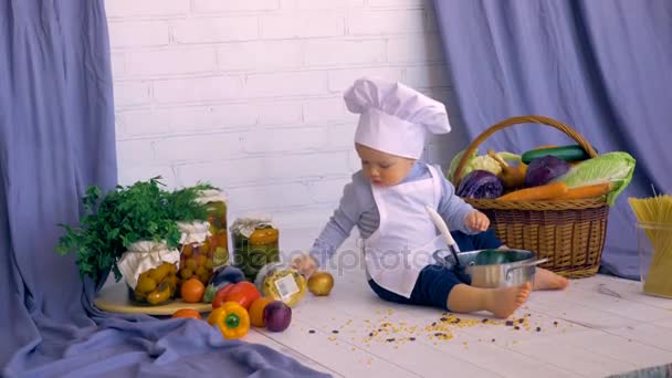 Adorável bebê macho criança na cozinha cozinhar, brincando com banco de lentilhas . — Vídeo de Stock